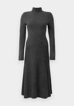 Vestido gris de punto con cuello alto, mangas largas y textura acanalada. Presenta un corte relajado con un dobladillo acampanado. Detalle de logotipo sutil.