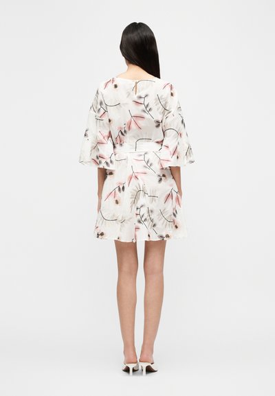 Φλοράλ κοντό φόρεμα από ελαφρύ ύφασμα, με ζώνη στη μέση και φαρδιά μανίκια. Χρώματα περιλαμβάνουν λευκό, ροζ και μαύρες λεπτομέρειες.