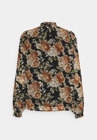 Blouse noire à manches longues avec imprimé floral beige et marron, col volanté, fermeture par bouton à trou à l'arrière et poignets élastiques.