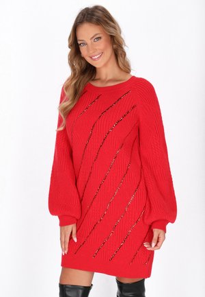Abito rosso lavorato a maglia con polsini a coste e una vestibilità rilassata. Presenta accenti diagonali dorati e motivi texturizzati, creando interesse visivo.