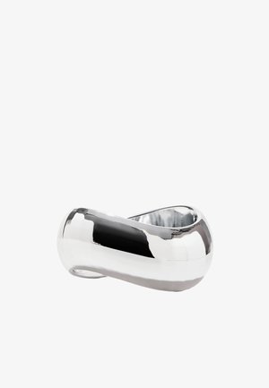 Bracelet en argent métallique avec un design lisse et courbé, présentant une boucle sans couture et une finition polie, mettant en valeur sa texture réfléchissante.