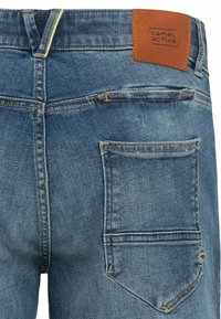 Blaue Jeans aus Denim mit einem Lederpatch mit der Aufschrift "camel active" am hinteren Bund und einem abgerundeten Design der Gesäßtasche.