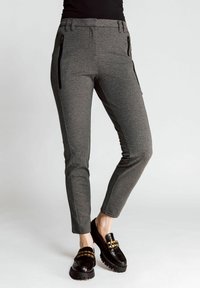 Gray knit trousers with a slim design, featuring side zip pockets and accent stitching. Paired with black loafers and a platform sole.