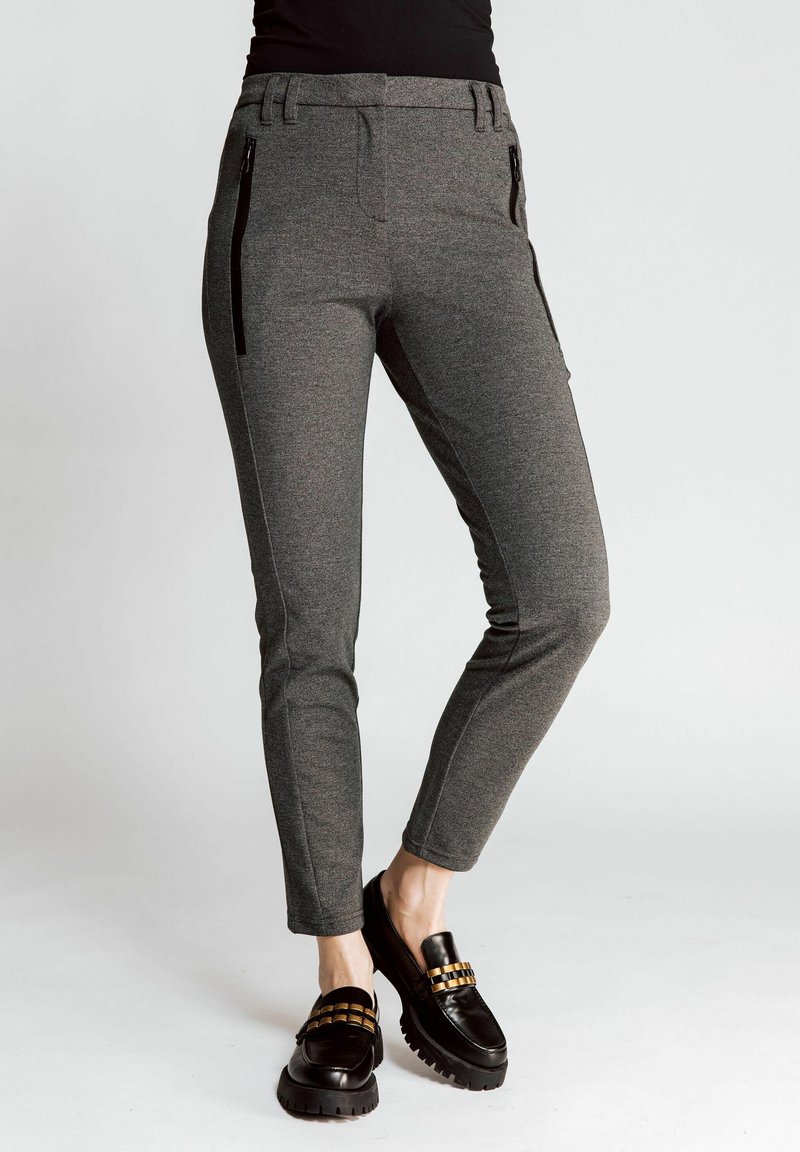 Gray knit trousers with a slim design, featuring side zip pockets and accent stitching. Paired with black loafers and a platform sole.