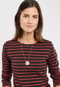 Maglietta a maniche lunghe con righe orizzontali nere e rosse, realizzata in un tessuto morbido. Presenta una collana con catena dorata e un pendente a forma di conchiglia.