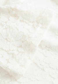 Spitzenstoff in Weiß mit Blumenmustern und einer strukturierten Oberfläche mit unterschiedlich dichten Fäden, die ein zartes, luftiges Erscheinungsbild erzeugen.