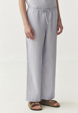 Licht paarse wijde linnen broek met een elastische tailleband en een trekkoord. Gemaakt in combinatie met bruine sandalen.