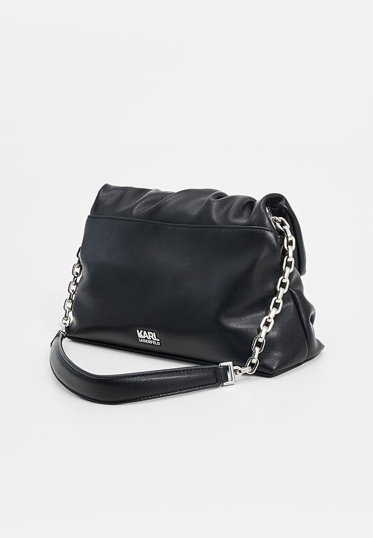 Bolso de cuero negro con un diseño arrugado, detalle de cadena plateada, correa ajustable y logotipo en la parte frontal.