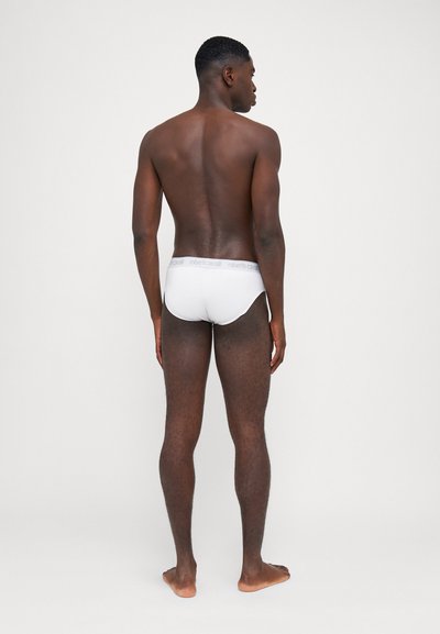 Caleçons en coton blanc avec une ceinture élastique grise arborant le logo "roberto cavalli". Le tissu est lisse et offre un ajustement serré.