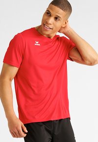 Rode sportieve T-shirt met korte mouwen, gemaakt van glad, lichtgewicht materiaal. Heeft een ronde hals en een wit logo op de borst.