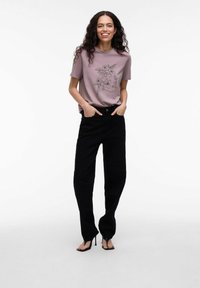 Lyslilla t-shirt med blomsterlinje-tegning kombineret med højtaljede sorte bukser og sorte hæle sandaler.