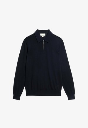 Donkerblauwe longsleeve polo shirt gemaakt van zachte stof, met een ritskraag en een gestructureerde kraag met een geribde zoom.