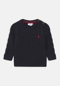 Granatowy dziergany sweter z wzorem w warkocz, okrągłym dekoltem i prążkowanymi mankietami. Posiada ozdobne guziki na ramieniu oraz czerwony akcent z logo.