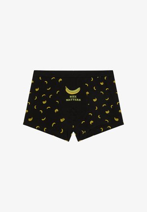 Boxer noir avec un motif de bananes jaunes et une grande banane au-dessus du texte "LA TAILLE COMPTE" au centre devant.