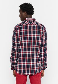 Geruite flanellen shirt in navy, rood en wit, met lange mouwen en een button-down kraag. Gestructureerde stof met een relaxte pasvorm.