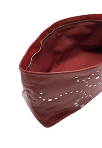 Czerwona skórzana torba o gładkiej fakturze, zdobiona metalowymi ćwiekami po jednej stronie i wyściełana tkaniną w środku. Zamek błyskawiczny widoczny.