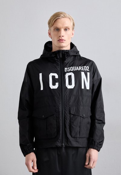 Veste à capuche noire avec le texte "DSQUARED2 ICON" en grandes lettres blanches, dotée d'une fermeture éclair et de poches frontales. Matière lisse et légère.