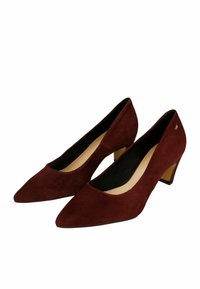 Décolleté in suede bordeaux con punta affilata e tacco basso a blocco. L'interno presenta un rivestimento beige. Piccolo accento metallico sul tacco.