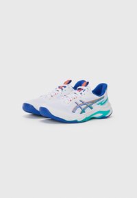 Baskets de sport blanches avec des accents bleus, tige en mesh, bouts arrondis, semelles en caoutchouc texturé et lacets multicolores. Présente un design de logo de marque.