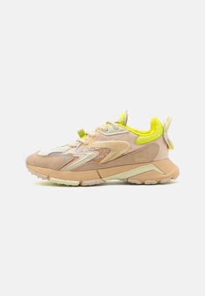 Lichtroze en beige sneaker met meshpanelen, een gevoerde tong en neongele accenten. Getextureerde zool met een bloemenmotief op de hiel.