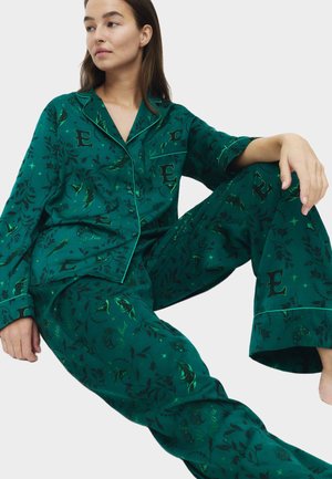 Green pajama set with floral and letter patterns, featuring a button-down shirt and wide-leg pants. Material appears smooth with contrasting trim.