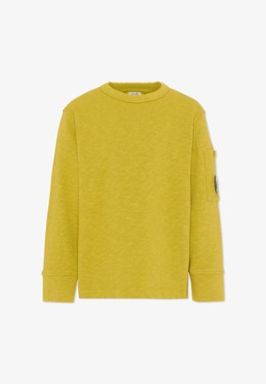 Felpa gialla a maniche lunghe con girocollo e una toppa rotonda in bianco e nero sulla tasca superiore della manica sinistra.