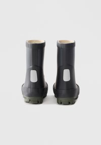 Botas de goma negras con un diseño de tobillo corto, con un panel gris en la parte trasera, suela texturizada y un forro interno cálido.
