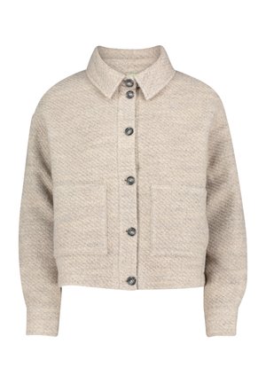Veste beige courte en tissu texturé, avec un col, six boutons foncés et deux poches avant.