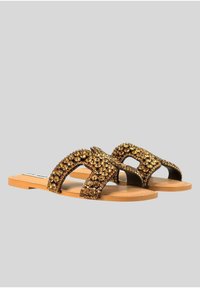 Sandali piatti con suola in gomma color testa di moro e cinghie decorative marroni con dettagli dorati, dotati di un design aperto sulla punta.