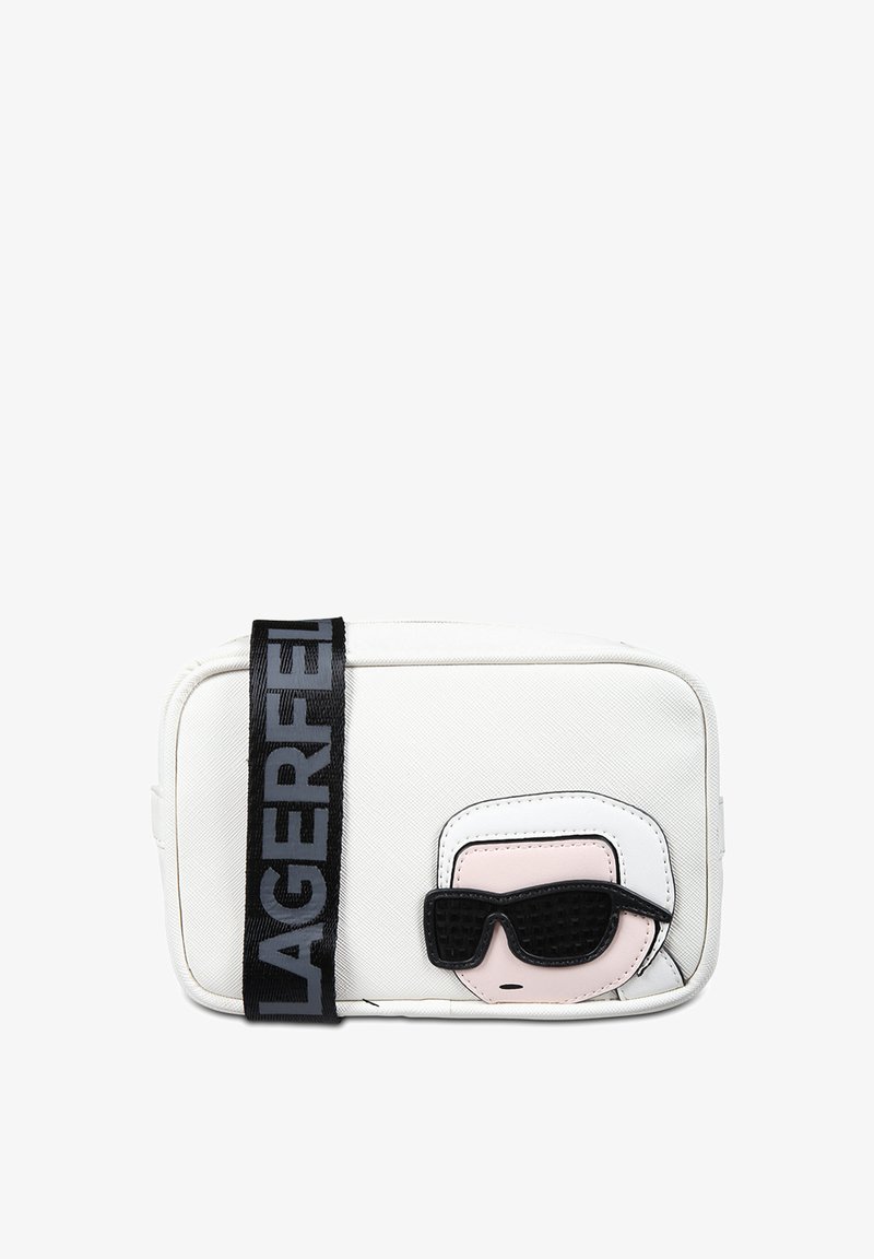 Sac bandoulière synthétique blanc avec un visage de cartoon noir et rose portant des lunettes de soleil ; doté d'une bandoulière noire audacieuse avec le texte "LAGERFELD".