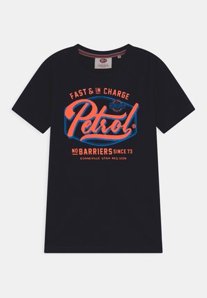 Granatowy t-shirt z krótkim rękawem z pomarańczowo-niebieskim logo „Petrol” oraz napisami „Fast & In Charge” i „No Barriers Since 73” z przodu.