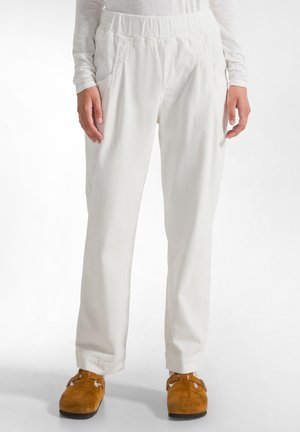 Pantaloni din corduroy albi cu dungi texturate, talie elastică și buzunare laterale. Croi larg, design cu picior tapered, completat de papuci maro.