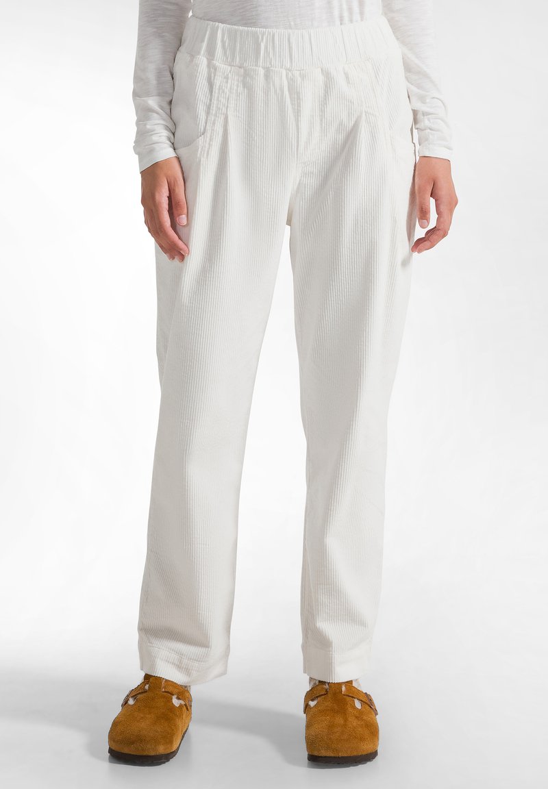 Witte corduroy broek met gestructureerde strepen, elastische tailleband en zijzakken. Losse pasvorm, tapered leg design, aangevuld met bruine slippers.