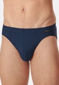 Dunkelblaue Herren-Schwimmslips mit vertikalen Streifen, weichem Stoff, elastischem Bund und einem kleinen Logotag an der Seite.