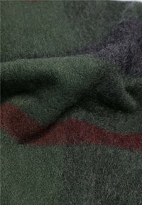 Tela de lana en verde oscuro y burdeos, que presenta una superficie suave y texturizada con capas dobladas y sutiles variaciones de color.