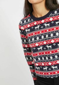 Stickad tröja i marinblått, rött och vitt med geometriska mönster, älgmotiv och rund halsringning. Texturerad tyg med en figurnära design.