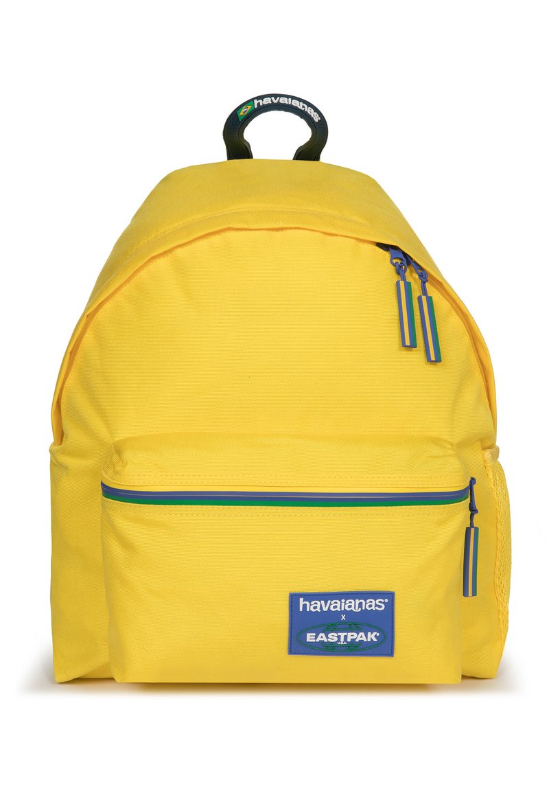 Zaino giallo dalla forma arrotondata, in tessuto, con una tasca frontale con zip decorata con accenti blu e verdi e una maniglia superiore per il trasporto.