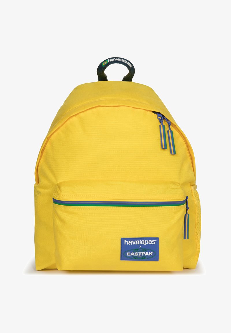 Zaino giallo dalla forma arrotondata, in tessuto, con una tasca frontale con zip decorata con accenti blu e verdi e una maniglia superiore per il trasporto.