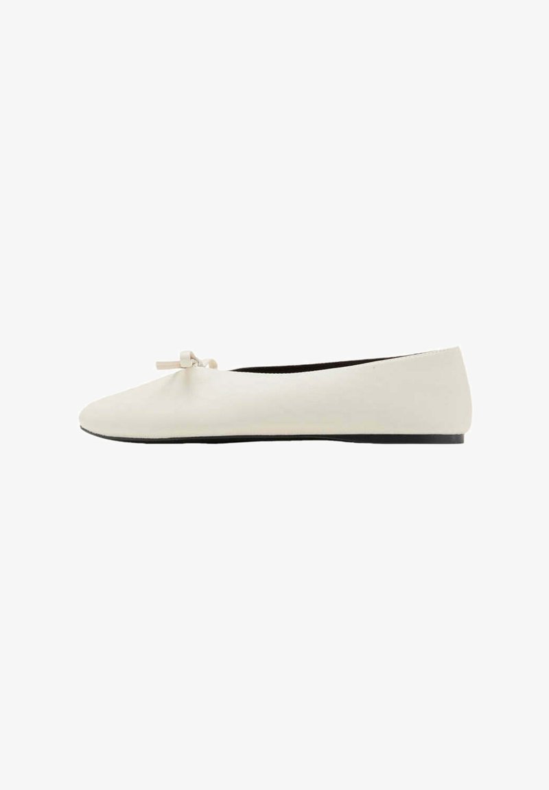 Ballerine femme écrue avec un petit nœud sur l'avant-arrondi et une fine semelle noire.