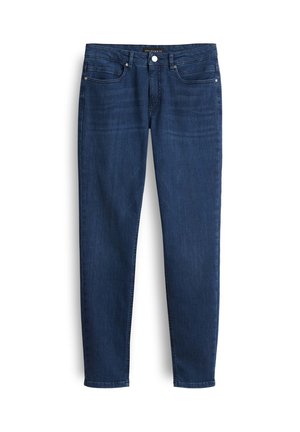 Donkerblauwe denim jeans met een slim fit, vijf-pocket ontwerp en een ritssluiting. Beschikt over subtiele vervaging en een merklabel op de tailleband.