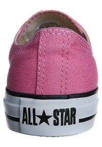 Zapatilla de lona rosa vista desde atrás, con el logo "ALL STAR" en la suela de goma blanca con rayas negras.