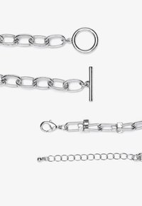 Silver metal chain bracelet featuring oval links, a toggle clasp, and a lobster clasp. Textured and polished surfaces with a shiny finish.
