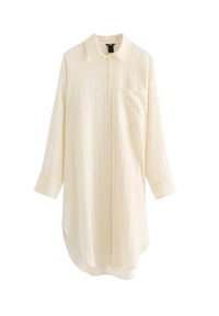 Camicia a maniche lunghe color crema chiaro con bottoni frontali, colletto puntato, taschino singolo sul petto e tessuto strutturato. Orlo curvo per un aspetto allungato.