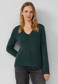 Dunkelgrüner Strickpullover mit V-Ausschnitt, gerippten Bündchen und Saum. Hat eine strukturierte vertikale Linie an der Vorderseite. Weicher und gemütlicher Eindruck.
