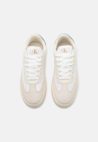 White and beige sneakers with smooth leather and suede materials. Lace-up design with brand logo on tongue, rounded toe, and low profile.