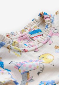 Beebikombe volangiga kraega ja värvikate loomade ning muusikariistade trükkidega heledal kangal.