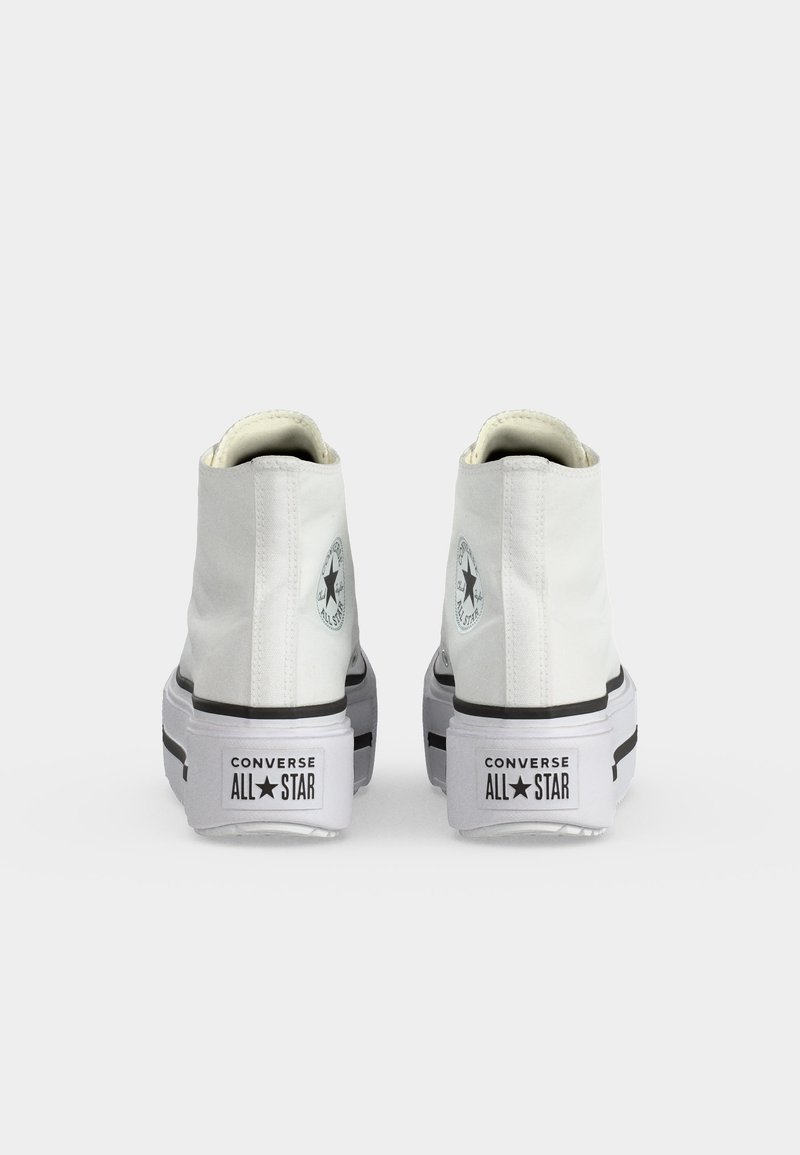 Paio di sneakers Converse All Star alte bianche mostrate da dietro, con suole spesse e logo nero sui talloni.