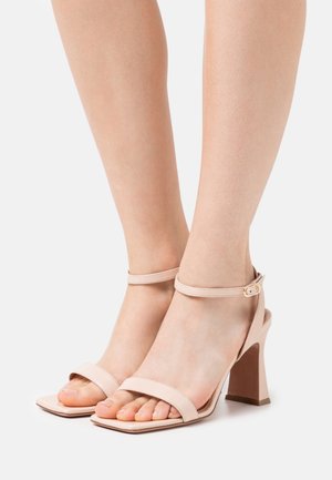 Helle rosa Absatzsandalen mit quadratischem Zehendesign, Knöchelriemen und Blockabsatz. Glattes Leder mit minimalistischem Design.