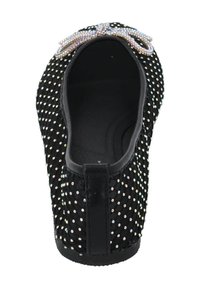 Zapato plano negro con una parte superior de tejido texturizado, adornado con pequeños strass multicolores y un lazo en la parte delantera. Suela plana.