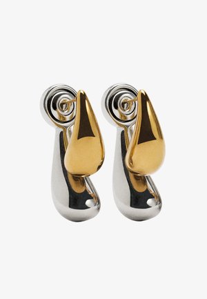 Polerowane metalowe klamki do drzwi o eleganckim wzornictwie; jedna strona jest złota, druga srebrna. Cechują się zaokrąglonymi kształtami i spiralnymi ozdobami.